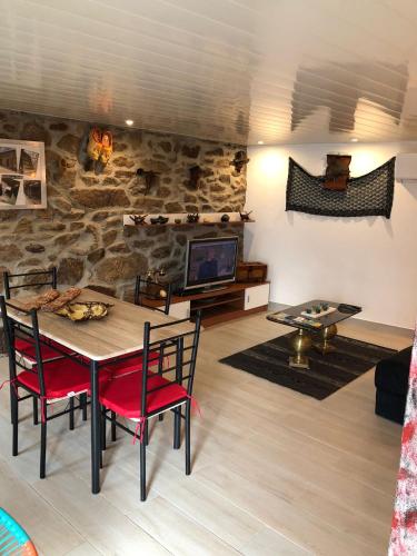 a living room with a table and chairs and a tv at Casas do Lobo in Tarouca