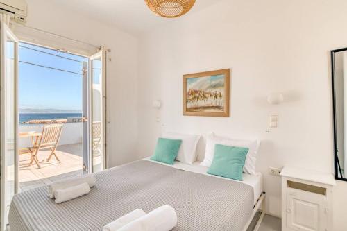 Habitación blanca con cama y balcón. en Sand And Seas: Villa Asterias, en Ampelas