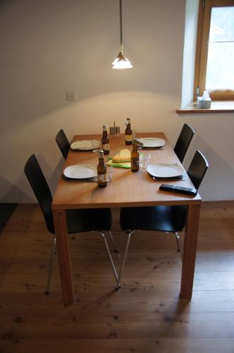 a wooden table with chairs and bottles on it at Chasa Pro La Tuor Pitschna in Ardez