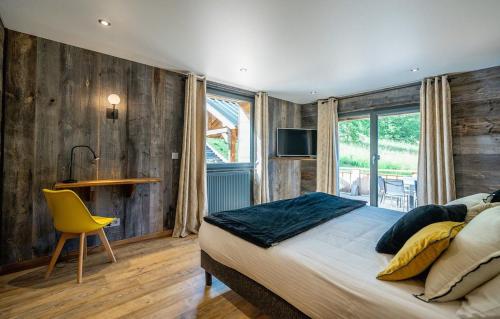 1 dormitorio con cama, mesa y silla amarilla en Chalet Le Petit Bes by Leavetown Vacations en Les Deux Alpes