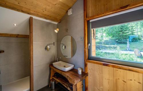 baño con lavabo, espejo y ventana en Chalet Le Petit Bes by Leavetown Vacations en Les Deux Alpes