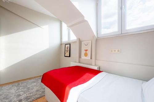 a white bedroom with a red blanket on a bed at Flat 7 min to Coast in Suadiye in Istanbul