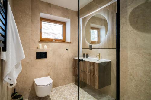 a bathroom with a toilet and a sink and a mirror at Apartament Widokowe Polany by Apart Concept Podhale in Kościelisko