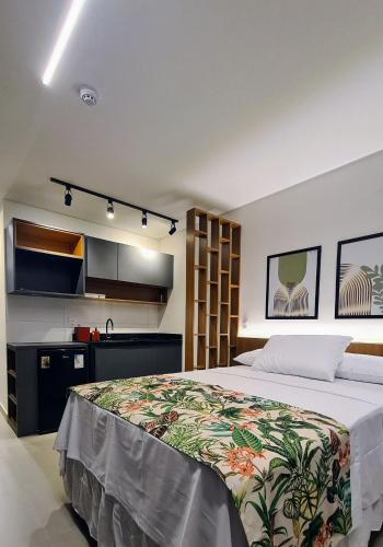 a bedroom with a large bed and a kitchen at Flats Tramonto - By EasyHost in João Pessoa