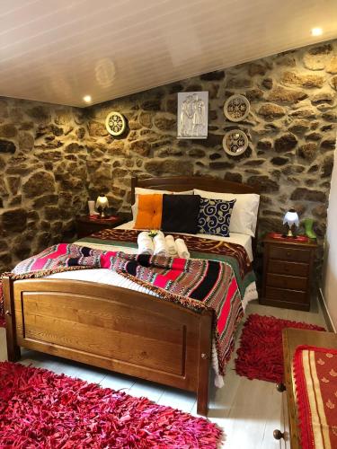 Tarouca的住宿－Casas do Lobo，一间卧室设有一张床和石墙