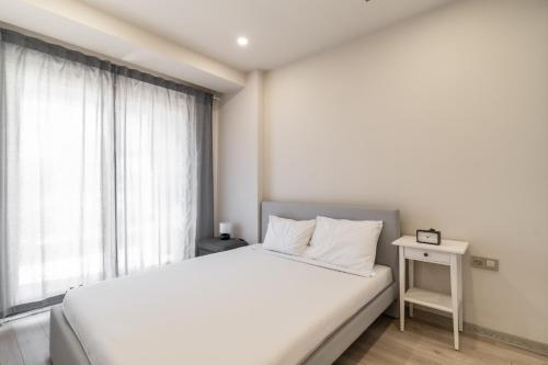 - une chambre blanche avec un lit et une fenêtre dans l'établissement Central Studio w Balcony 10 min to Lara Beach, à Antalya
