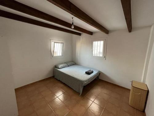 a bedroom with a bed and two windows at Large Apartment in el Raval in Barcelona