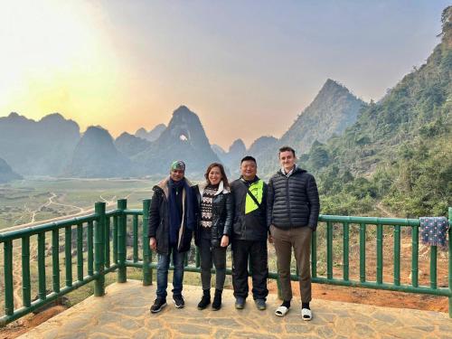 um grupo de pessoas em pé em frente a uma montanha em Lan’s home em Cao Bang
