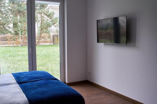 a bedroom with a bed and a television on a wall at Top Loft Znana in Warsaw