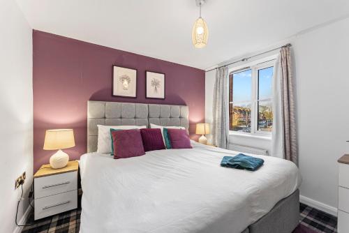- une chambre avec un grand lit aux murs violets dans l'établissement Designer Apartment - Great Location!, à Manchester