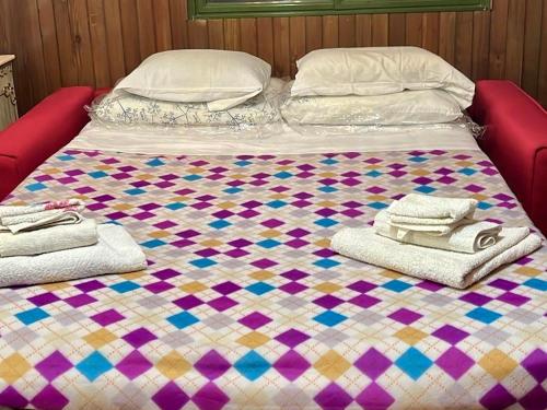 uma cama grande com uma colcha e toalhas em Casa San Rocco em Roccaraso