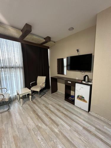 ein Hotelzimmer mit einem TV und einem Wohnzimmer in der Unterkunft Motel Blue Corner in Erbil