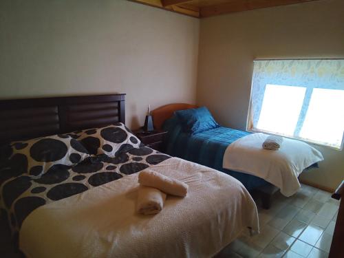 Łóżko lub łóżka w pokoju w obiekcie Cabaña los sauces