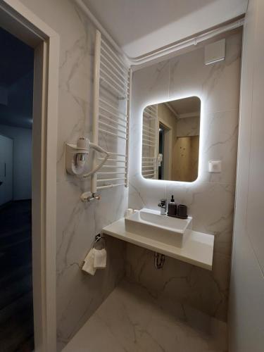 a bathroom with a sink and a mirror at Hotel Central in Pécs