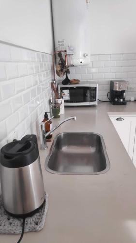 a kitchen counter with a sink and a microwave at Benarés in Puerto Madryn
