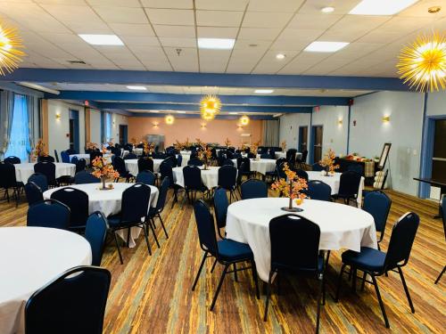 a banquet hall with white tables and chairs at Albany Airport Inn in Albany
