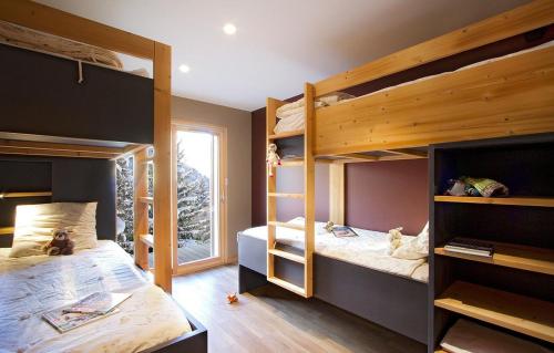 een slaapkamer met 2 stapelbedden en een raam bij Chalet Leosky by Leavetown Vacations in Les Deux Alpes