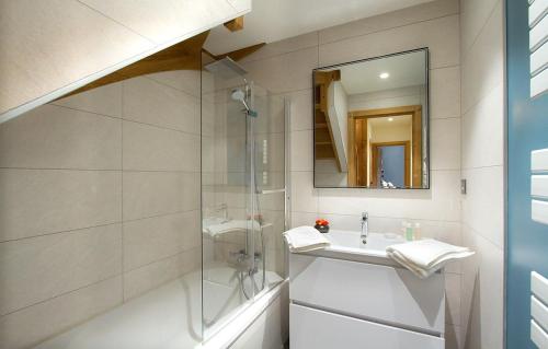 een badkamer met een douche, een wastafel en een spiegel bij Chalet Leosky by Leavetown Vacations in Les Deux Alpes