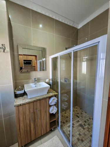 a bathroom with a sink and a shower at Villa Marche in Van Riebeekhoogte