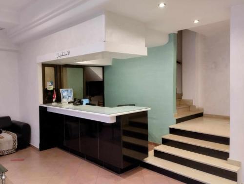 a kitchen with a counter and stairs in a room at Hotel yasmine in Sfax