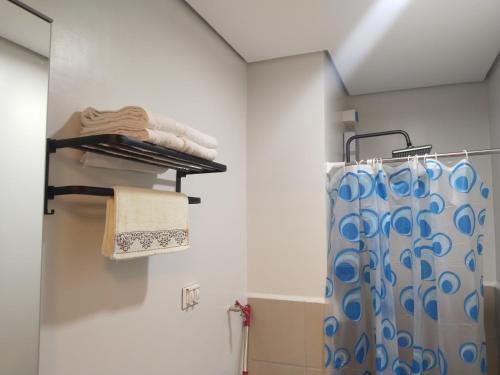 a bathroom with a shower and a shower curtain at C516 Place at SMDC Cheer Residences by Lee Portum in Marilao