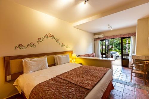 una camera da letto con un letto grande in una stanza di Villa di Mantova Resort Hotel ad Águas de Lindóia