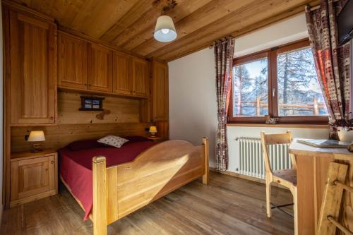 a bedroom with a bed and a desk in a room at Le Coin des Mélèzes - NATURE & TREK in Brusson