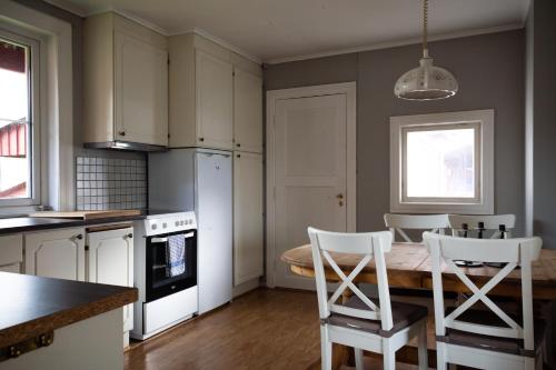 a kitchen with a table and chairs in a kitchen at Osloveien 6 in Røros
