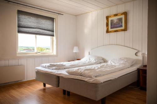 a bed in a room with a large window at Osloveien 6 in Røros