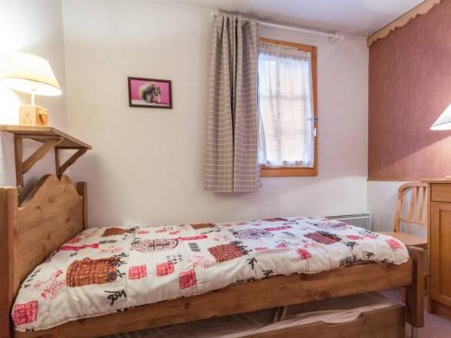 une chambre avec un lit avec une couette dessus dans l'établissement Appartement fonctionnel au centre avec balcon à La Plagne - FR-1-181-2543, à La Plagne Tarentaise