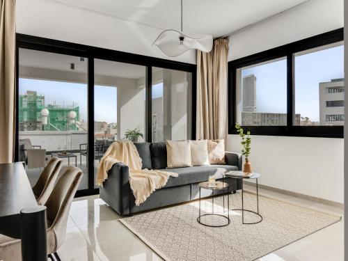 a living room with a couch and large windows at Sanders Premier Downtown in Limassol