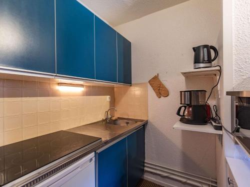 une cuisine avec des armoires bleues et un évier dans l'établissement Appartement cosy 6 pers, 1 ch, à 80m des pistes - La Mongie - FR-1-404-349, à La Mongie