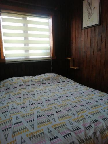 a bedroom with a large bed with a window at Hostal Casa Damasco in Ancud