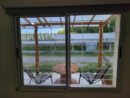 a window view of a patio with a table and chairs at Casa de Campo Flor Dorada in Centenario