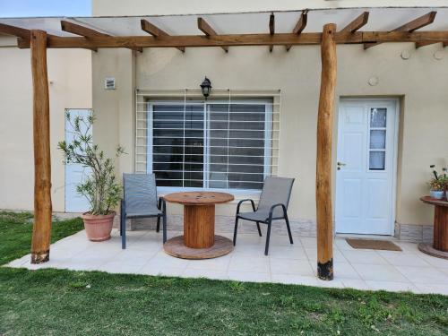 a patio with a table and chairs in front of a house at Casa de Campo Flor Dorada in Centenario