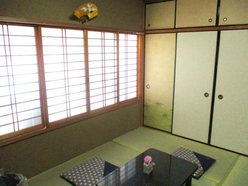 una stanza con un tavolo e due grandi finestre di Uji - House - Vacation STAY 9753 a Uji