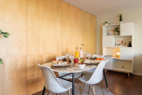 een eetkamer met een tafel met witte stoelen bij Restful Minimalist Flat - Balcony in Porto