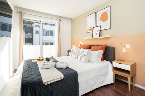 a bedroom with a large bed and a window at Host Wise - Restful Minimalist Flat - Balcony in Porto