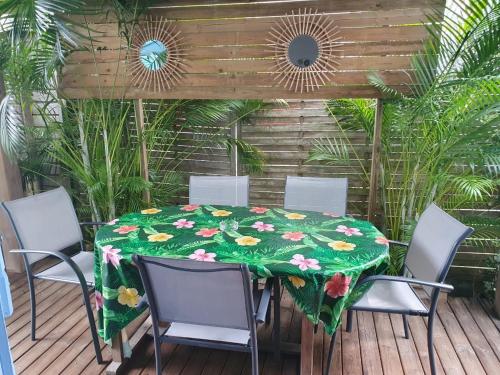 a table with a green table cloth on a deck at Bungalows MALUEVA in Sainte-Anne