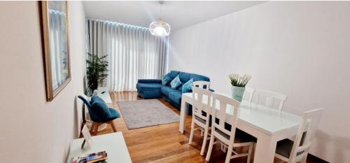 sala de estar con sofá azul y mesa en Ocean Pearl Apartment V, en Funchal