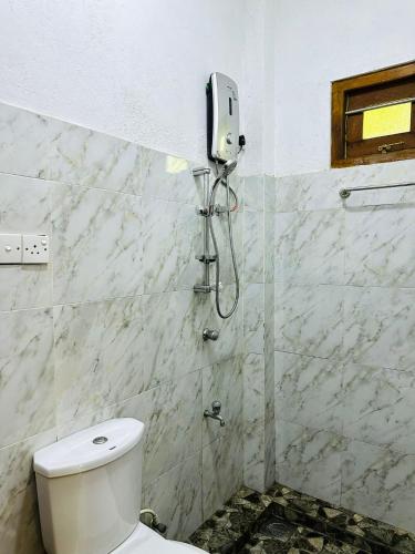 a bathroom with a toilet and a phone on the wall at lake paradise in Habaraduwa