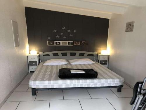 Una cama con una bolsa negra en un dormitorio en Maison Caraïbes en Le Barcarès