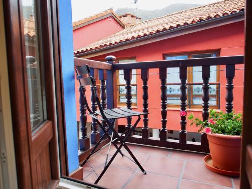 a black chair on a balcony with a red house at Hostal Remoña in Espinama