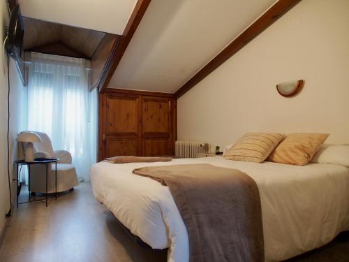 a bedroom with a large bed with a wooden ceiling at Hostal Remoña in Espinama