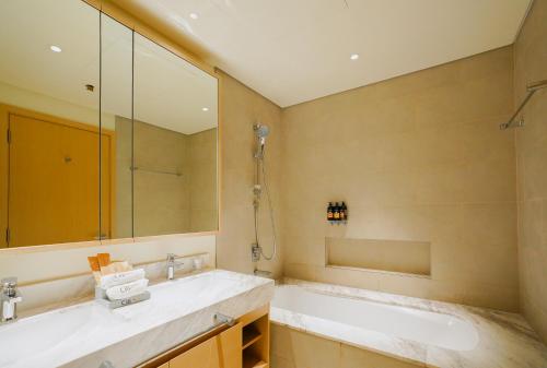 a bathroom with a large mirror and a sink at CitiHome-2BR creek harbour island in Dubai
