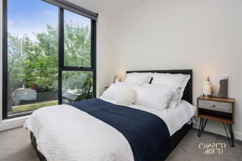 1 dormitorio con cama y ventana grande en Chapter 3 Airbnb in Malvern East, en Melbourne