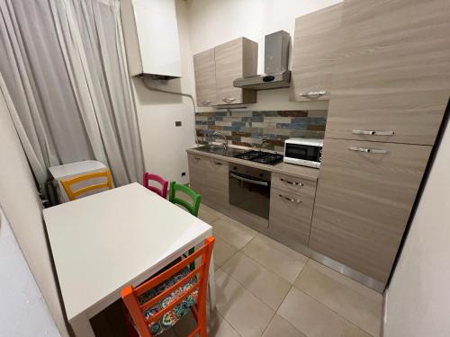 罗马COLONNA HOLIDAY HOME的小厨房配有白色的桌子和炉灶。