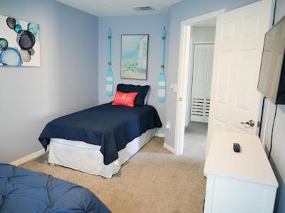 Dormitorio azul con cama con almohada roja en Terra Verde Resort, en Kissimmee