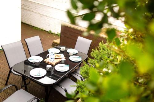 a black table with plates and cups on a patio at Beach in Reach in Eastbourne