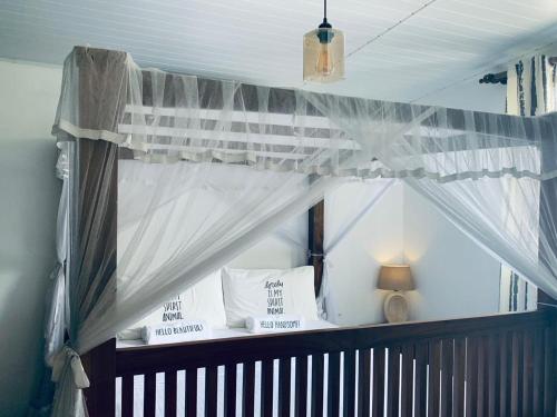 a canopy bed with white curtains and pillows at My place Sri Lanka Apt Near Airport (CMB) in Katunayake